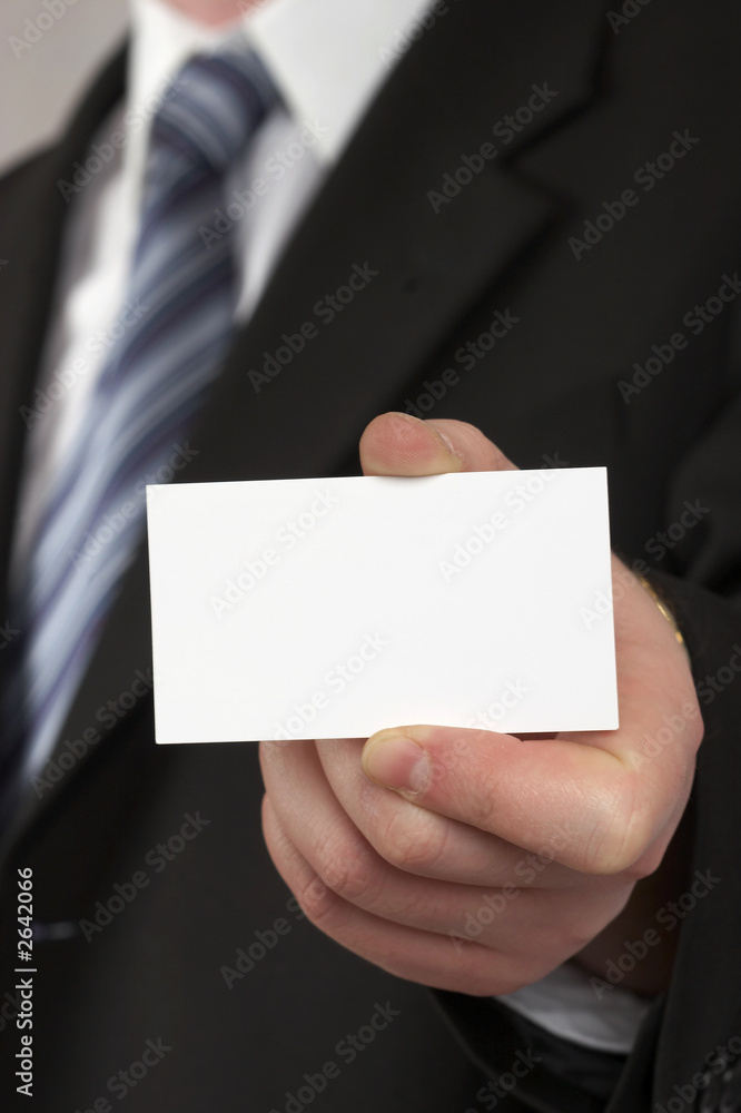 the businessman in a suit and a tie. hand with a white card . the businessman in a suit and a tie. hand with a white card .