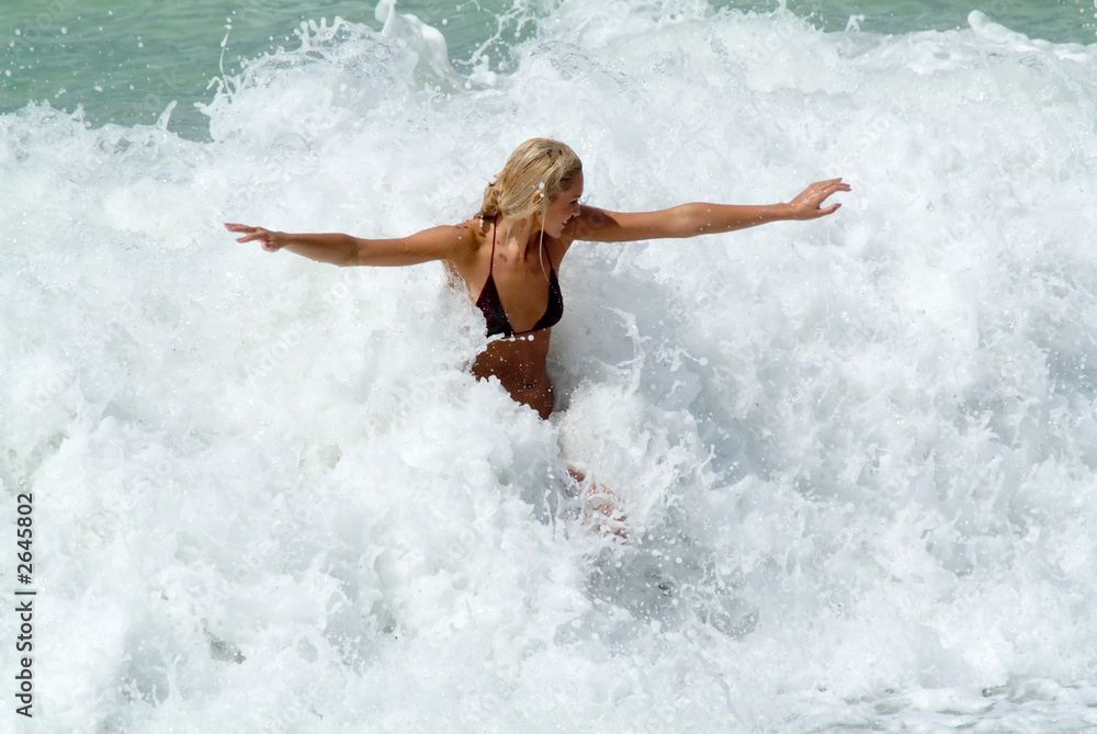 young woman play in waves