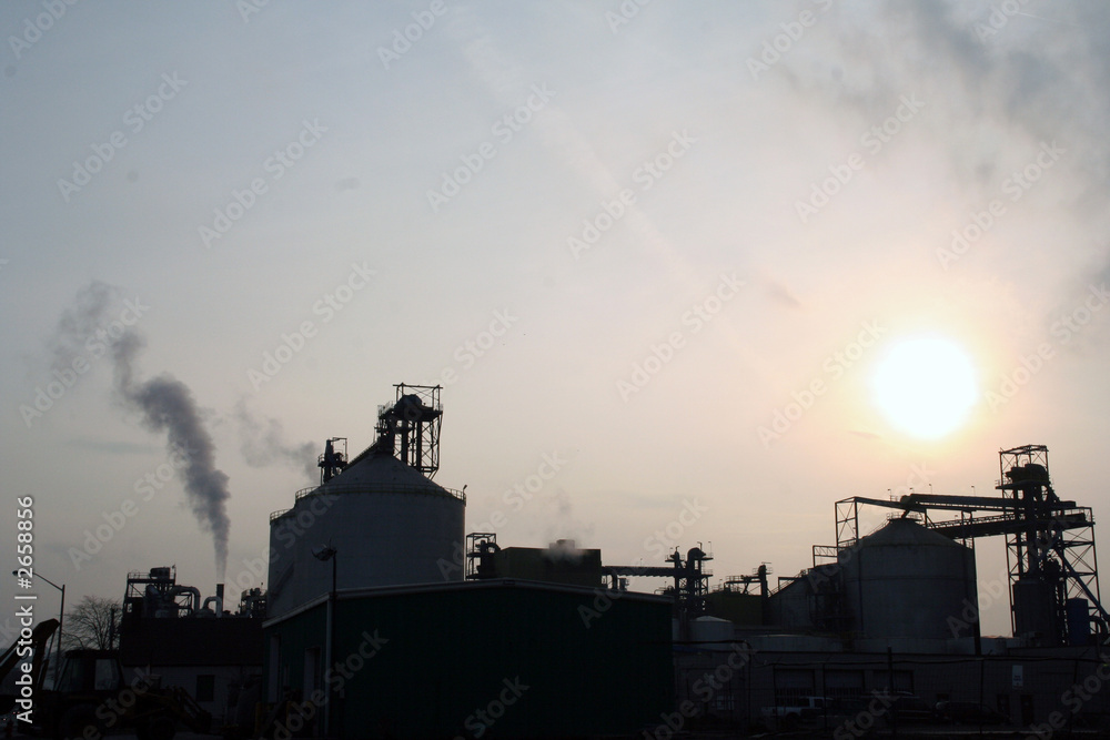 factory silhouette with sun in background
