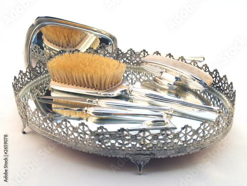 ornate silver brush in intricate tray