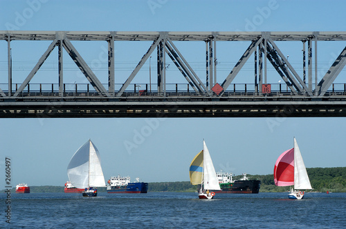 yachts and float sea vessels under the bridge on the river don