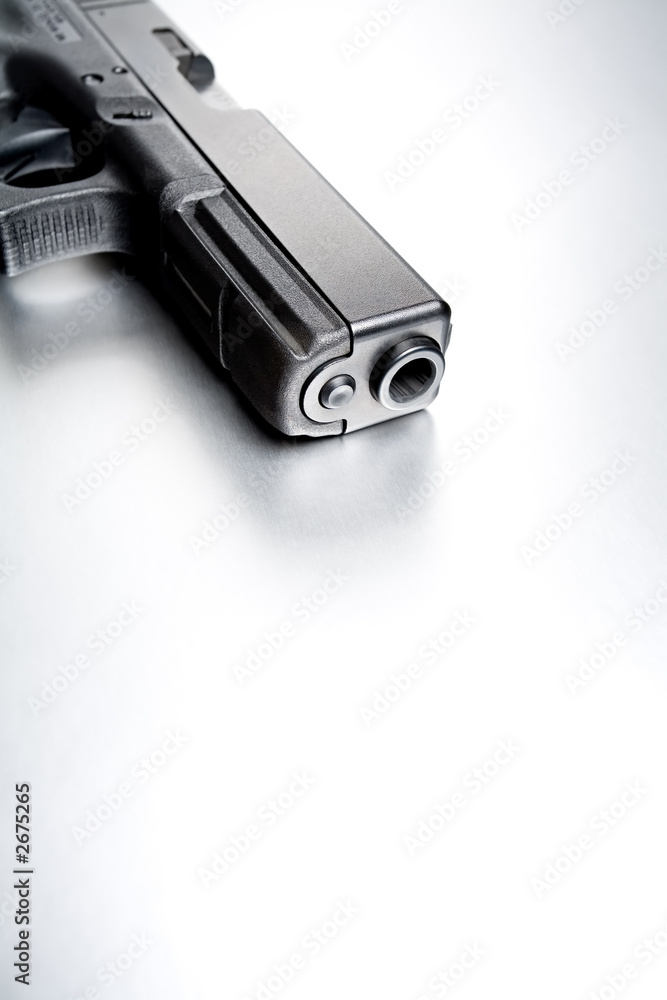 gun on brushed metal background gun on brushed metal background
