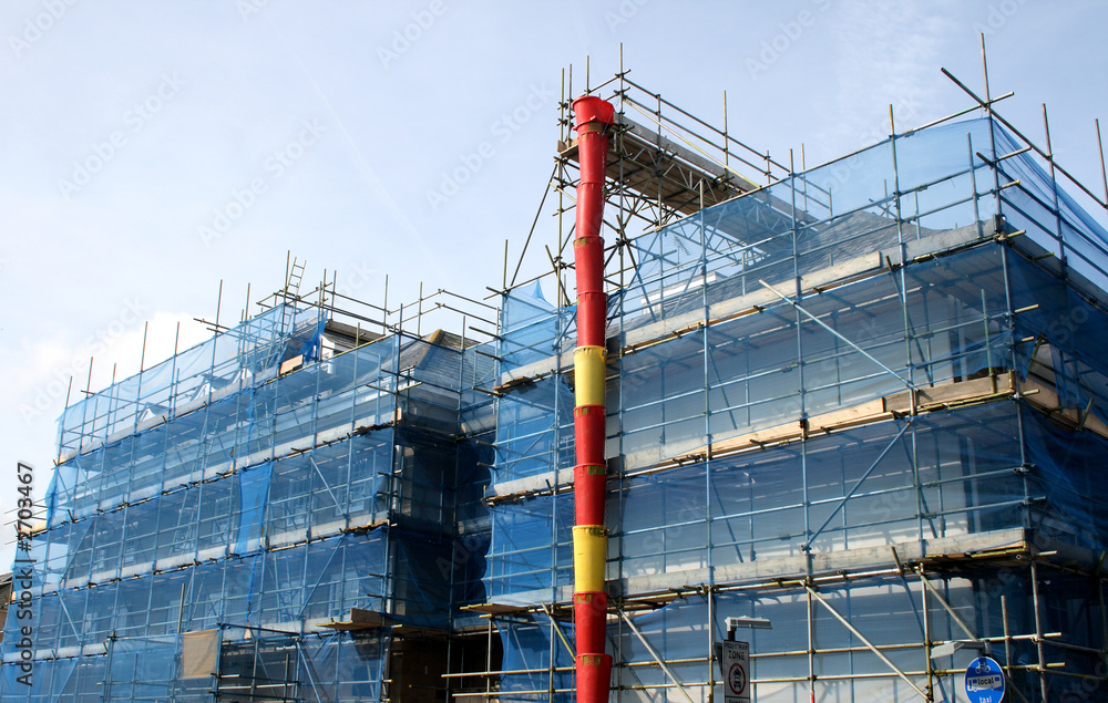 a building covered in scaffolding and tarpaulin an