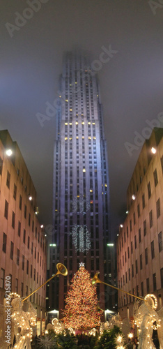 angel playing trumpet for christmas and high tower in the back w