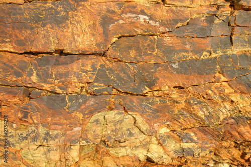 orange colored shoreline cliff face rock surface.
