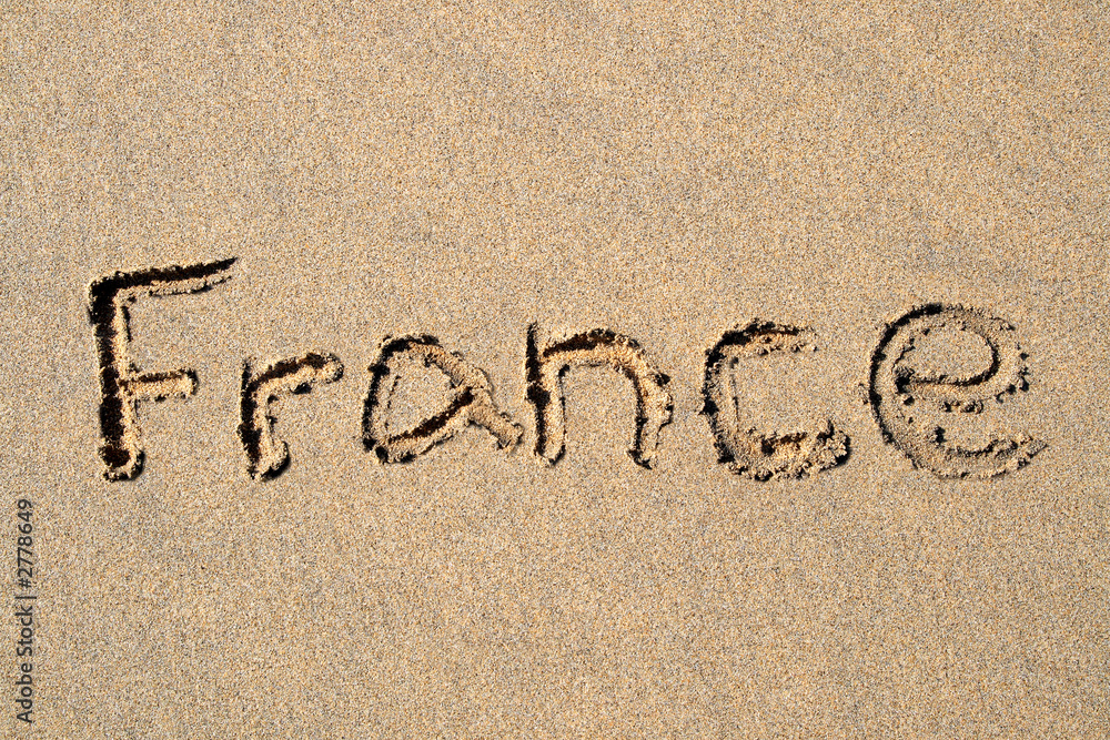 Fototapeta premium france, written on a sandy beach.