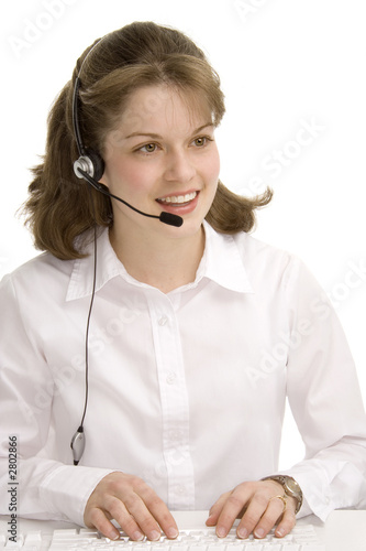 female receptionist with headphones, typing, commu