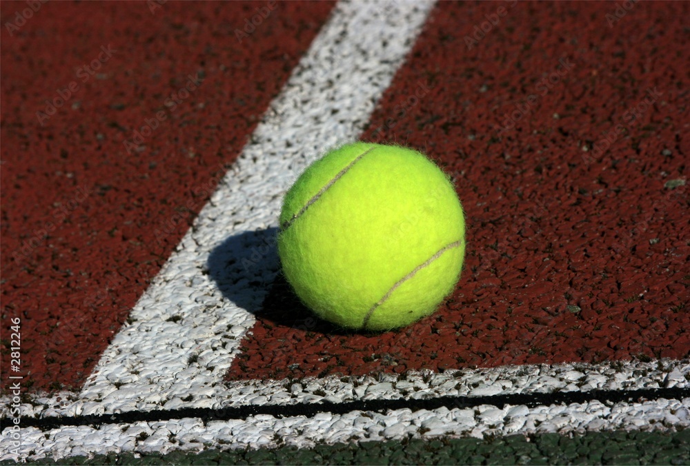 tennis ball in the corner of a tennis field