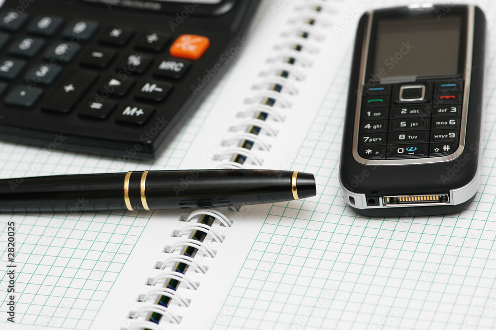 calculator, ballpen and mobile phone on the notebook calculator, ballpen and mobile phone on the notebook