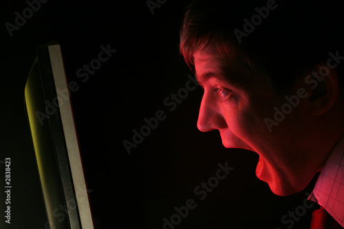 man screaming at red computer monitor