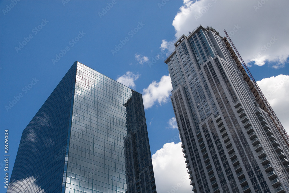 blue sky with clouds shines through office towers