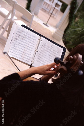violin player with music sheets outdoors
