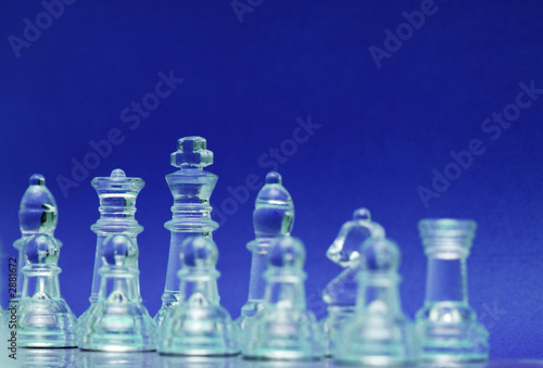 glass chess figures over the blue background