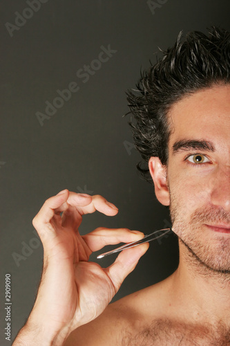 man pulling his beard with tweezer