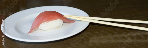 tuna sushi and two sticks on white plate