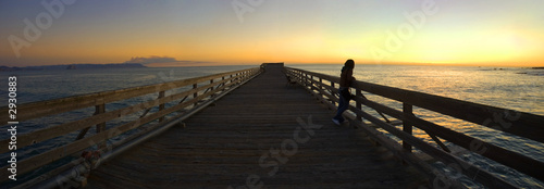 woman on a pier during sunset