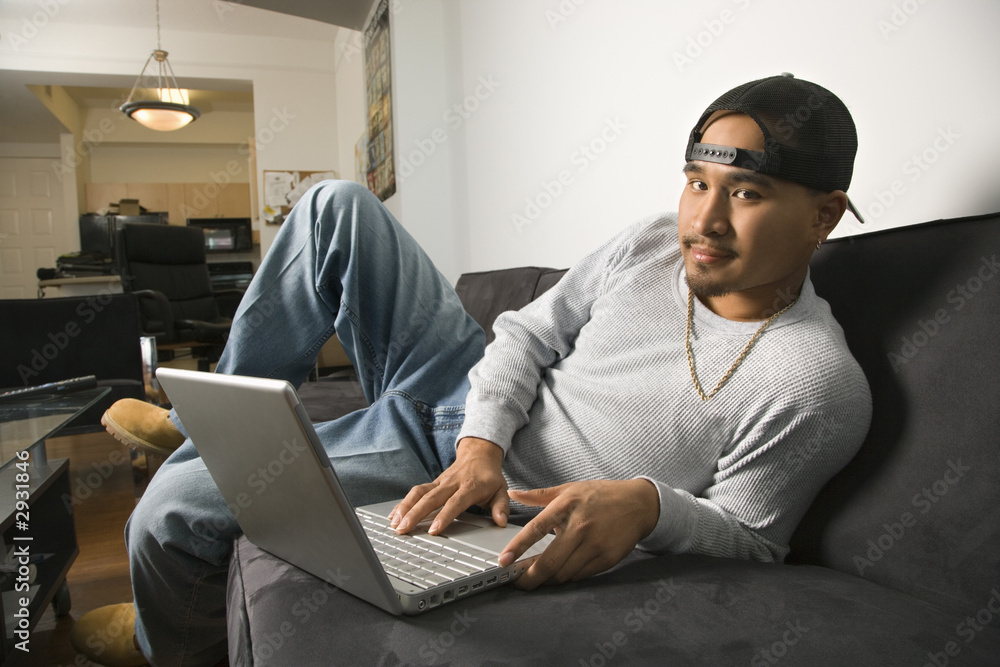 man sitting on sofa using laptop. man sitting on sofa using laptop.