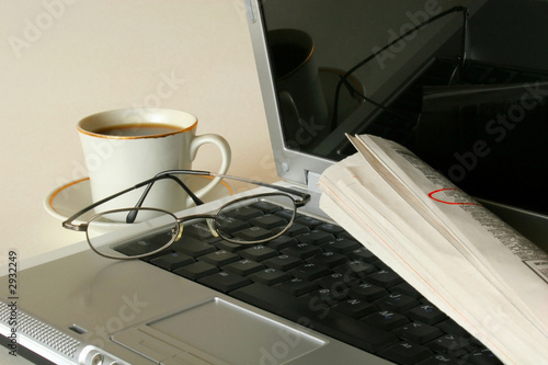job hunting with both laptop and newspaper