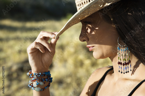 Φωτογραφία young woman tipping a cowboy hat.