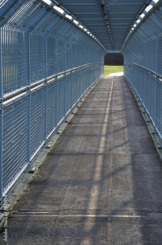 narrow path surrounded with iron fencing