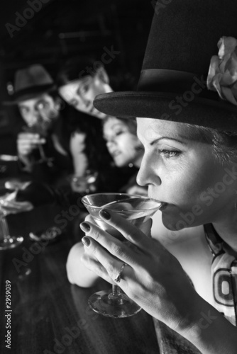 retro female sitting at bar drinking martini.