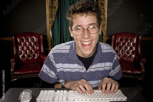 happy teenage boy on computer
