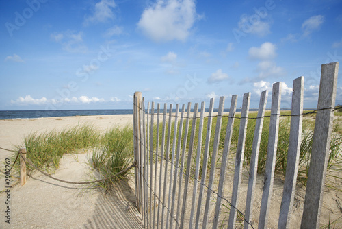 Weathered wooden fence on sand dune.
