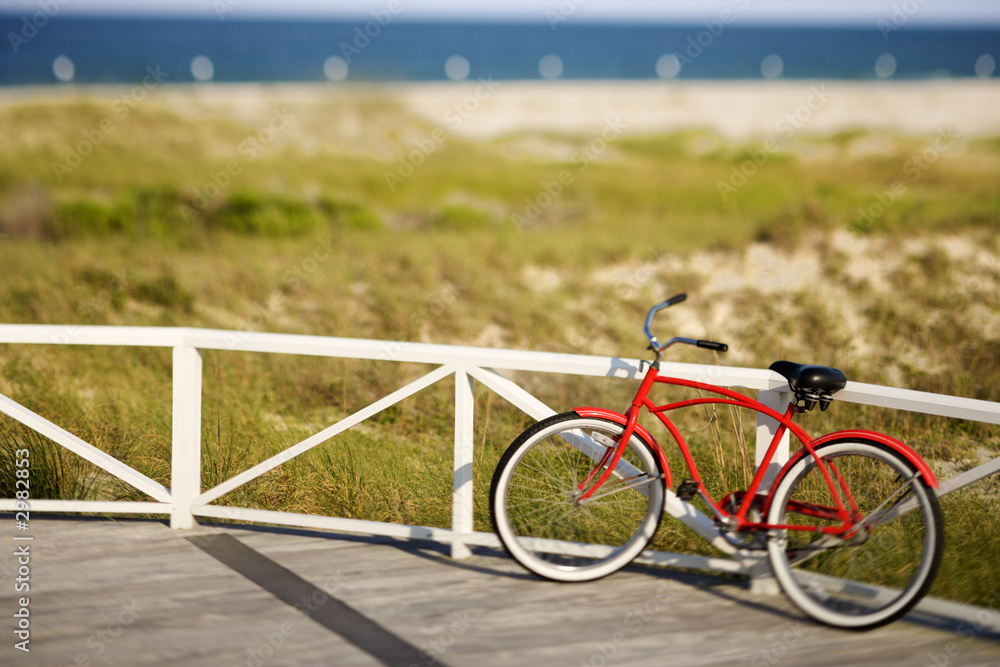 Fototapeta premium Bicycle leaning against rail on Bald Head Island, North Carolina