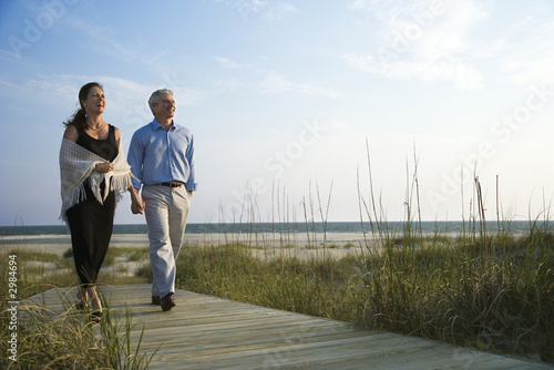 Obraz na płótnie Couple holding hands on coastal walkway.
