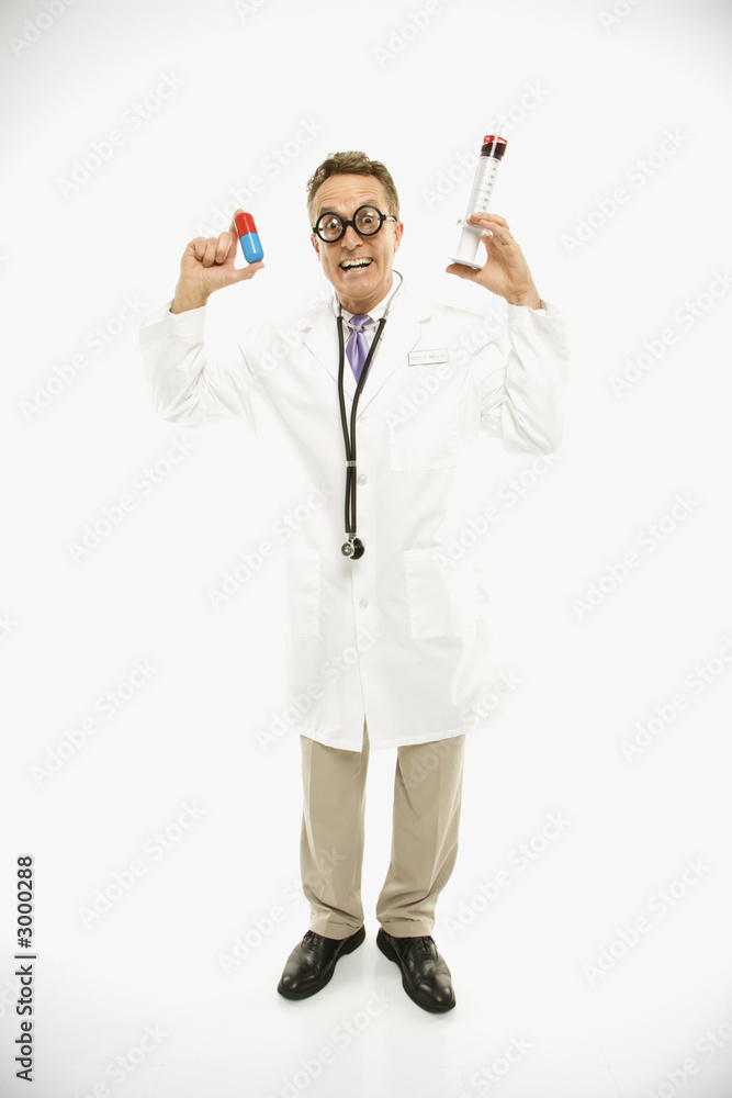 doctor holding an oversized pill and syringe. doctor holding an oversized pill and syringe.