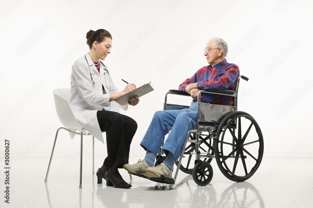 doctor taking notes with an elderly man in wheelchair to her sid doctor taking notes with an elderly man in wheelchair to her sid