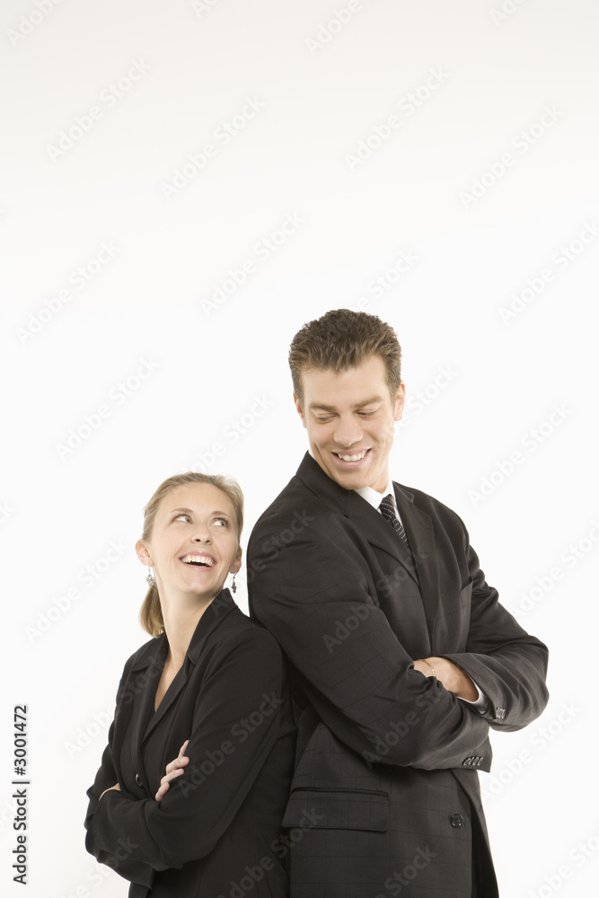 businesswoman and man standing back to back smiling. businesswoman and man standing back to back smiling.