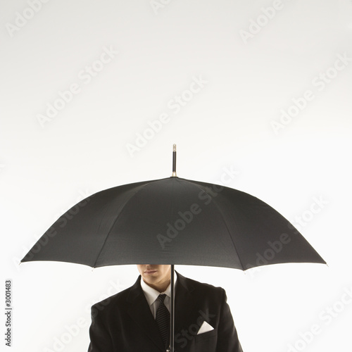 businessman with face covered by umbrella.