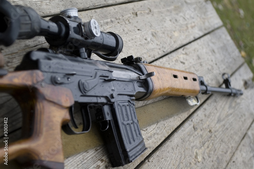 rifle gun laying on wooden desk