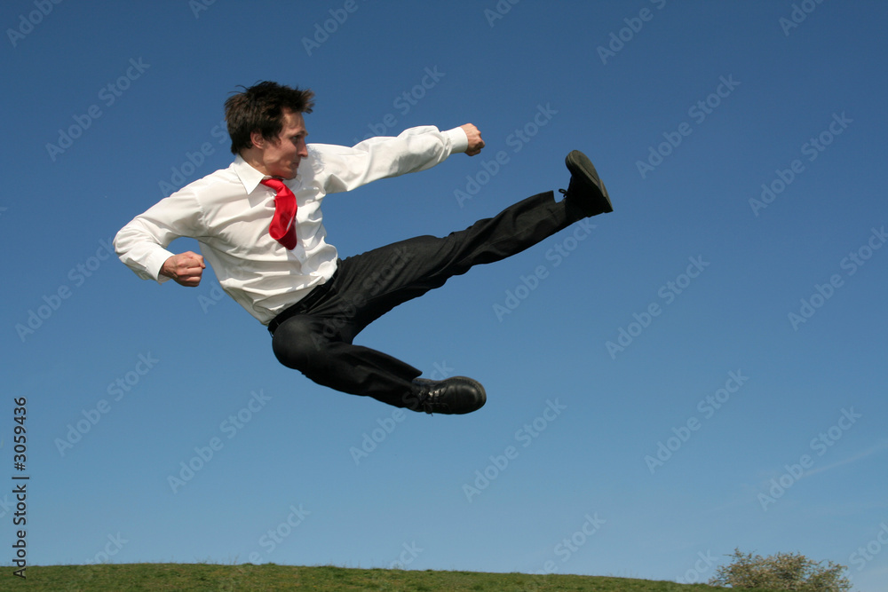 businessman doing a karate kick outdoors businessman doing a karate kick outdoors