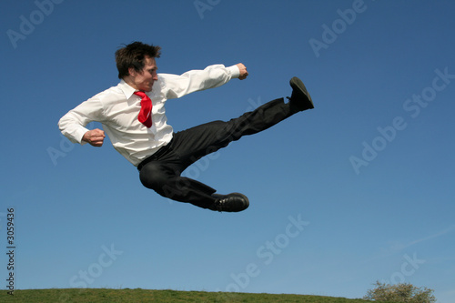 businessman doing a karate kick outdoors