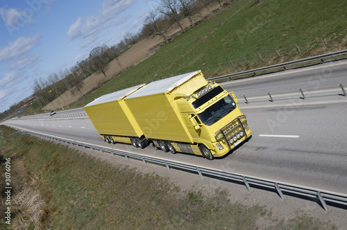 clean yellow truck on highway straight