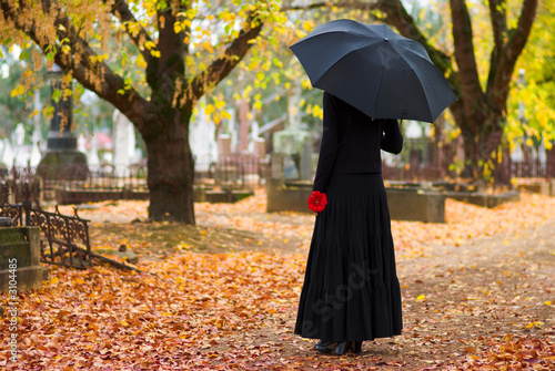 woman in mourning at cemetery in fall photo