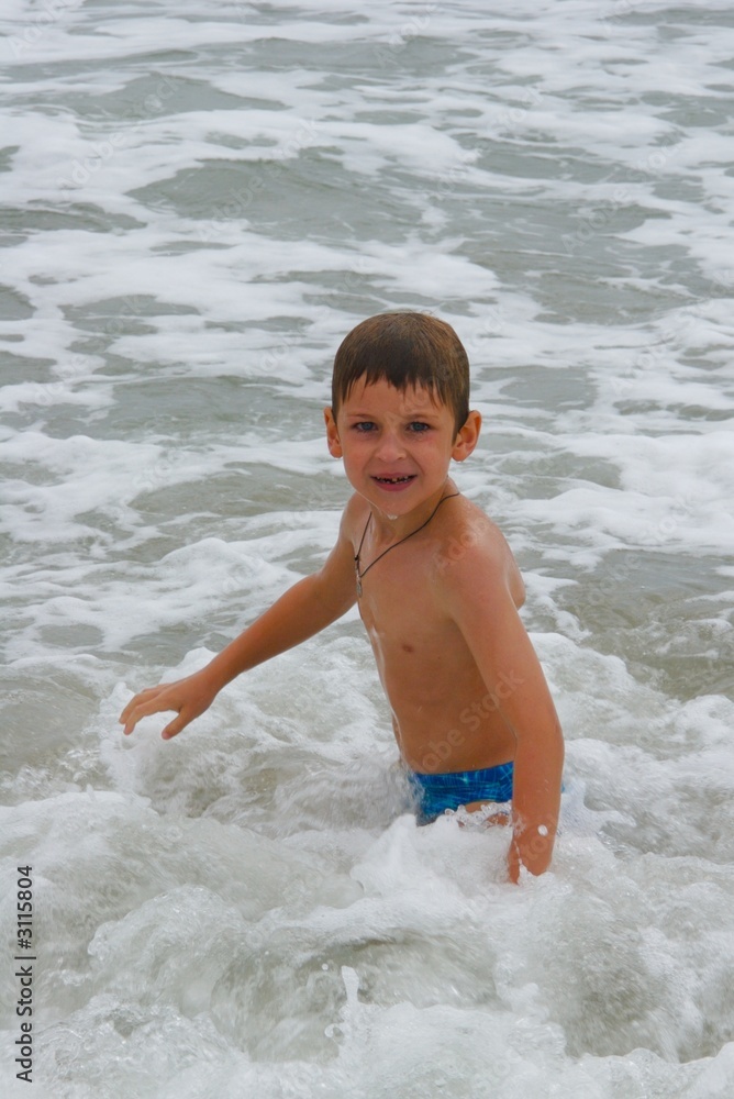 boy playing with ocean waves