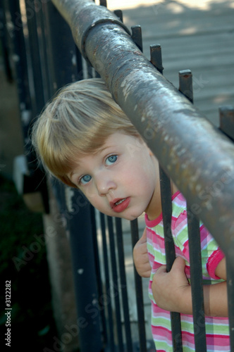 girl looking through bars