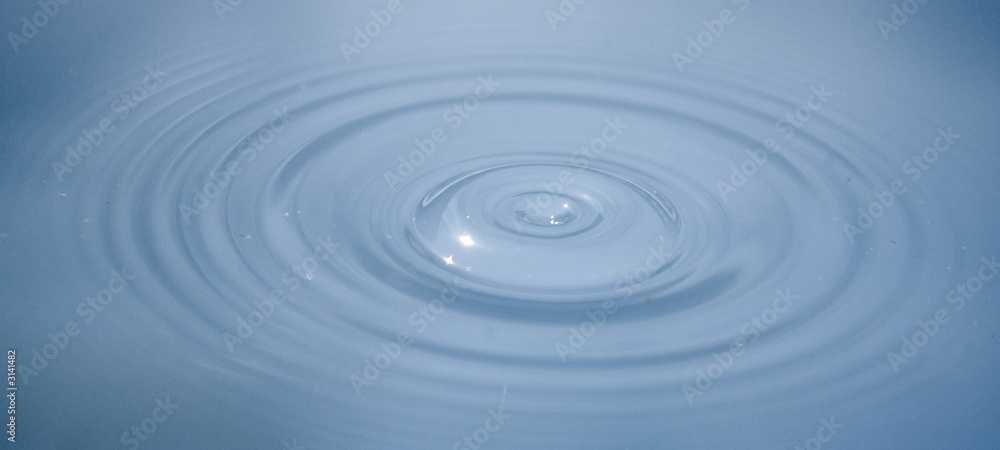 water with ripples spreading out after the surface was struck by a droplet