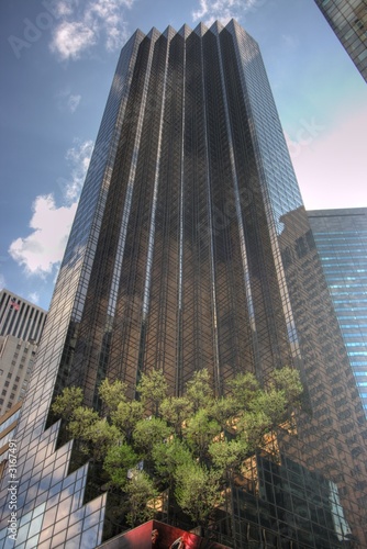 tall skyscraper with blue sky and trees photo