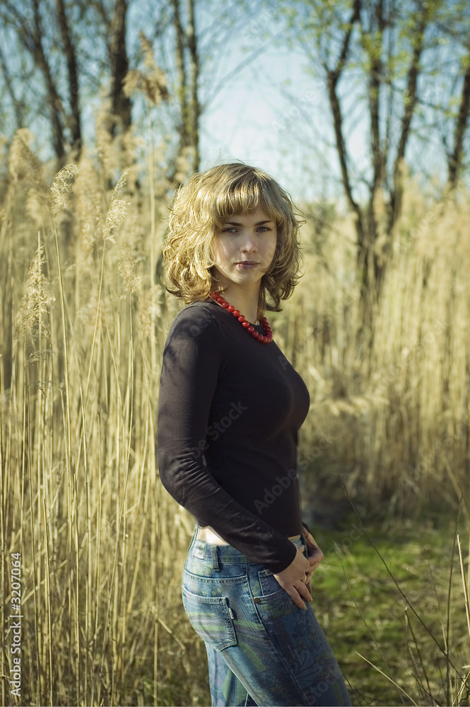 Obraz premium pretty blond standing behind a reed