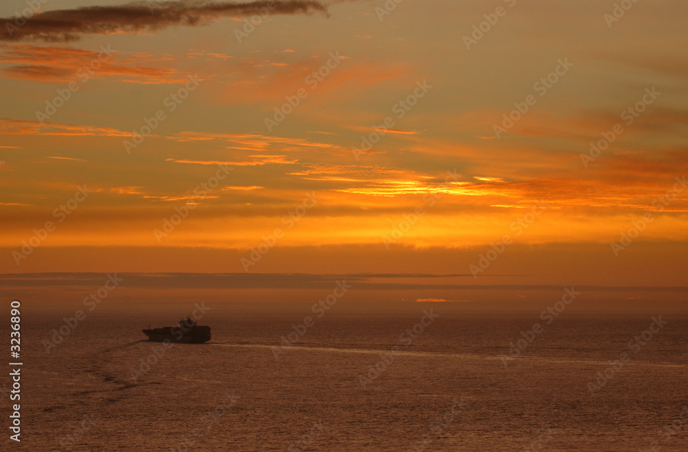 sunset over ocean and cargo ship sunset over ocean and cargo ship