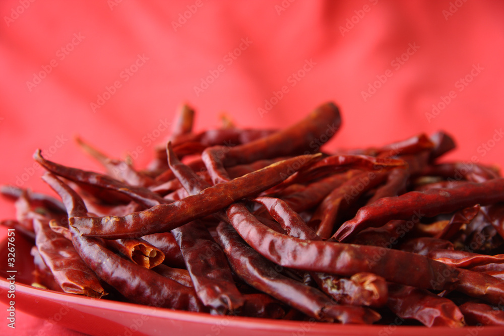 red hot chilli peper pods on scarlett-red
