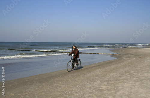 young lady cycling on the beach