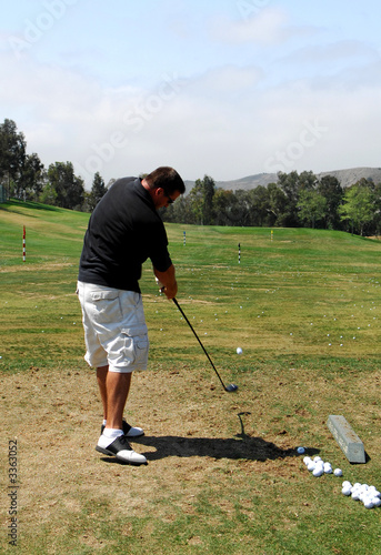 golf driving range - club impacts ball photo