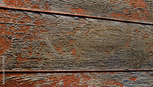brown flakes and faded paint on wood