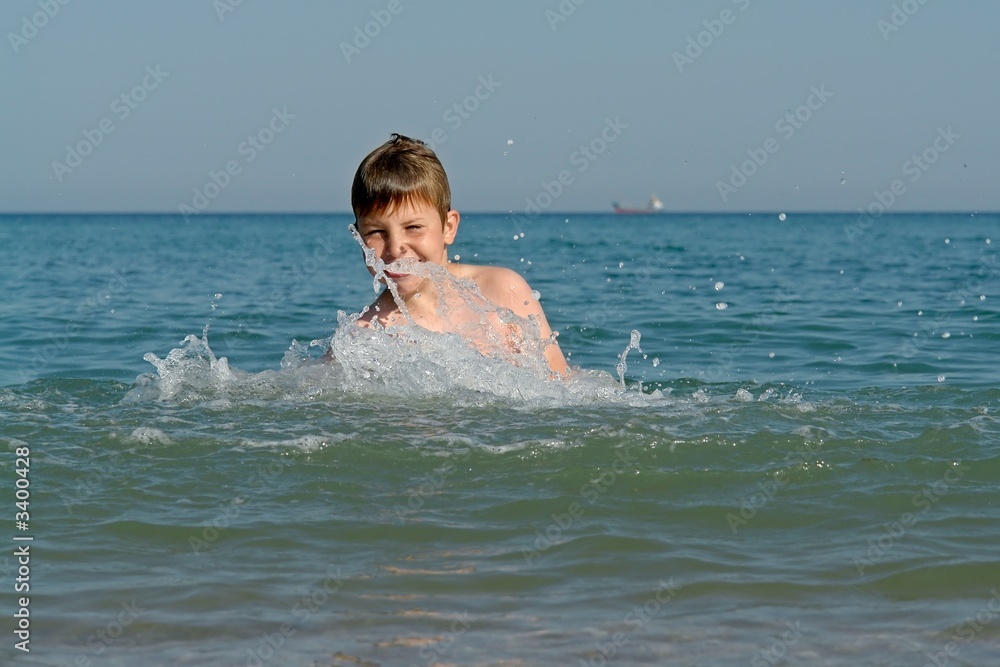 boy jumping into wave