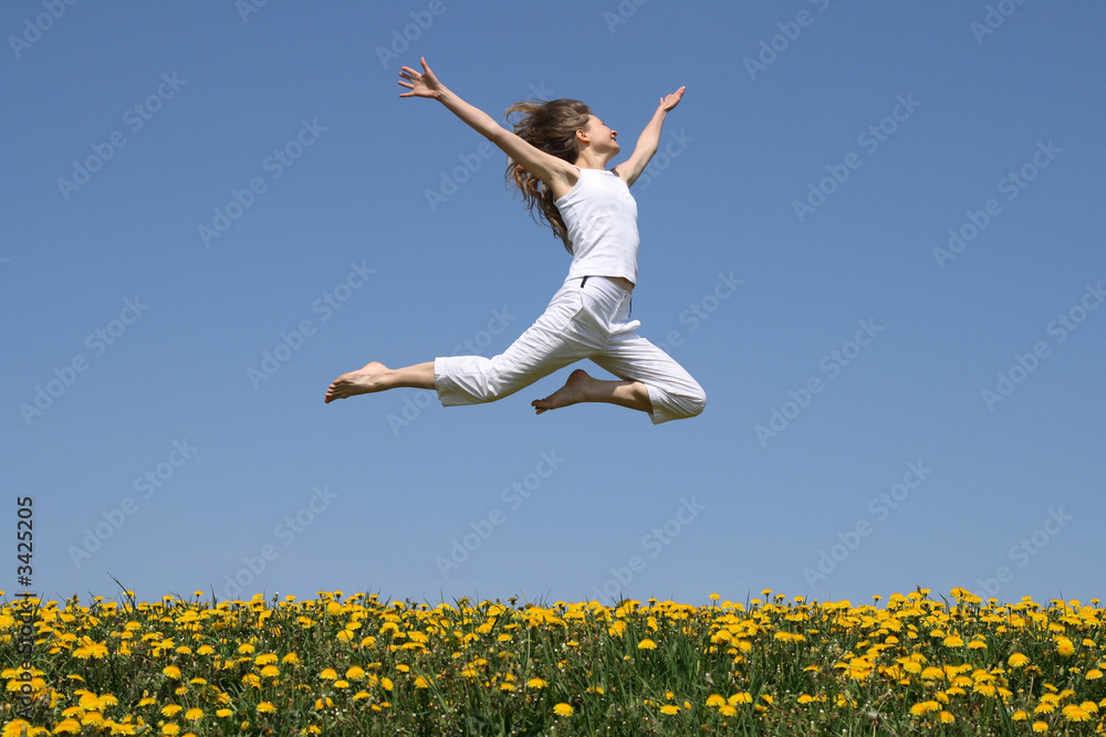 girl flying in a jump over dandelion field girl flying in a jump over dandelion field